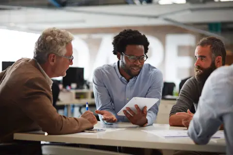Three Men in discussion around a table