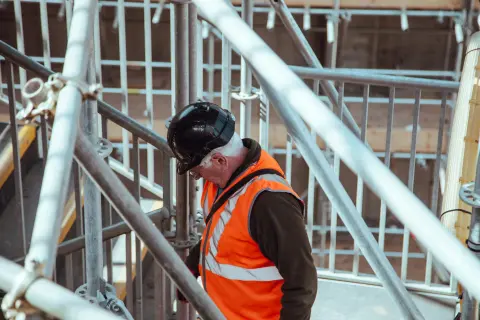 A foreman on scaffolding of a new building