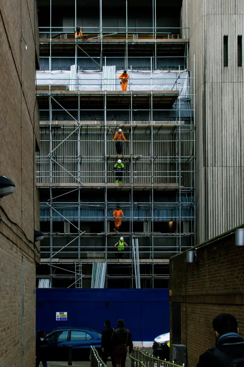 Construction workers on scaffolding of a new building