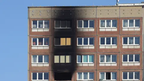 Facade of an old high-rise building in the UK on a backdrop of blue sky